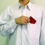 Main putting a card in his shirt pocket