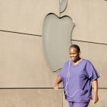 Woman in scrubs walking by Apple store