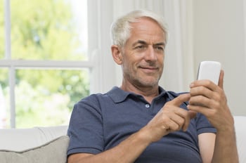 White haired man texting