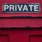 A red door with a letter slot in it, with the word "Private" written above the slot