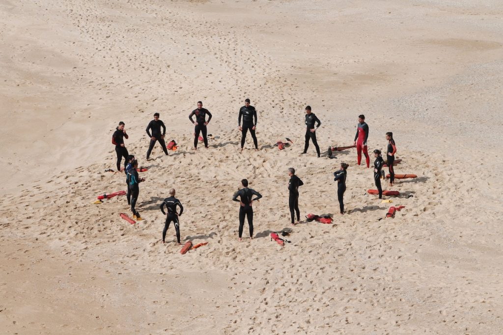 Lifeguards meeting in a circle on the sand